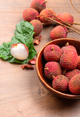 Fresh lychee with leaves isolated on wooden background.