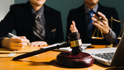 Business and lawyers discussing contract papers with brass scale on desk in office. Law, legal services, advice, justice and law concept picture with film grain effect