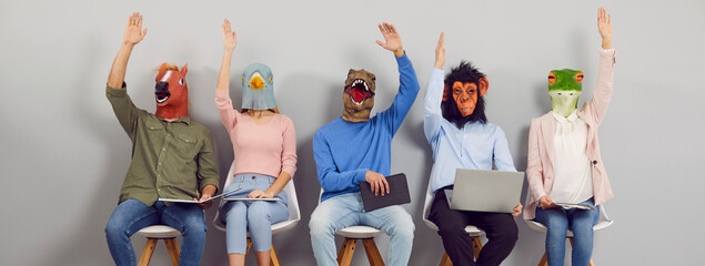 Team in funny animal masks demonstrate unanimous agreement as they vote for good suggestion at...
