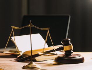 Business and lawyers discussing contract papers with brass scale on desk in office. Law, legal services, advice, justice and law concept picture with film grain effect