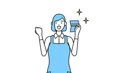 預金通帳を見て喜ぶエプロンを着た女性