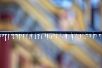 Icicles on wires near street houses. winter season nature