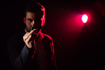 Close up photo of man showing middle finger on pink and black background.