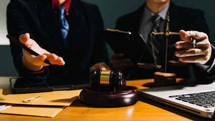 Business and lawyers discussing contract papers with brass scale on desk in office. Law, legal services, advice, justice and law concept picture with film grain effect