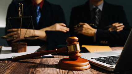 Business and lawyers discussing contract papers with brass scale on desk in office. Law, legal services, advice, justice and law concept picture with film grain effect