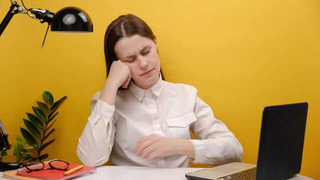 Portrait upset employee business woman in shirt sit work at white office desk with laptop spread hand shrugging shoulders looking puzzled, posing isolated over yellow color background wall in studio