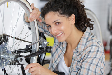happy female at home fixing her bike