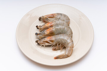 Fresh raw shrimp plated in a bowl on white background