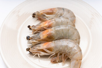 Fresh raw shrimp plated in a bowl on white background