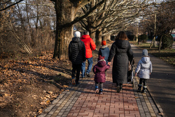 Back of family walking at pathway in a park.