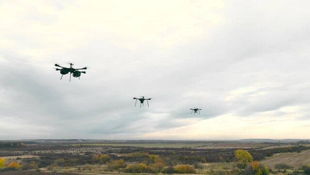 Combat military drones fly on the sky background.