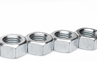 Set of steel nuts. On an isolated white background. With scratches. Close-up studio macro photography.