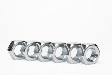 Set of steel nuts. On an isolated white background. With scratches. Close-up studio macro photography.