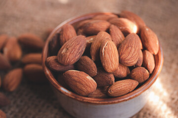Roasted almonds in a ceramic cup.Warm tone image.