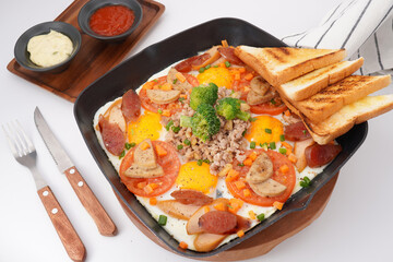 Fast food breakfast, fried eggs in pan and vegetables