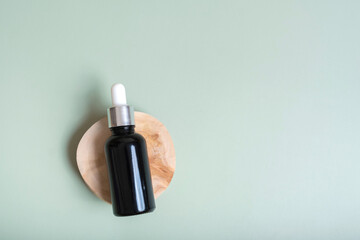 Cosmetic bottle with pipette on wooden slice top view, flat lay on colored background with lavender...