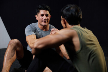 young athletic men meeting in the gym and shaking hands after workout