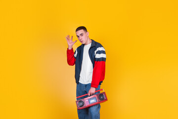 A handsome guy in the style of the 90s with a boombox on a yellow background
