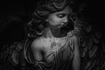 Black and white image of angel of death. Ancient destroyed statue. Fragment.