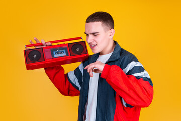 A handsome guy in the style of the 90s with a boombox on a yellow background