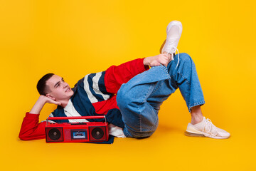 A handsome guy in the style of the 90s with a boombox on a yellow background