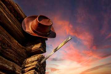 cowboy hat and a penknife on an abandoned cabin