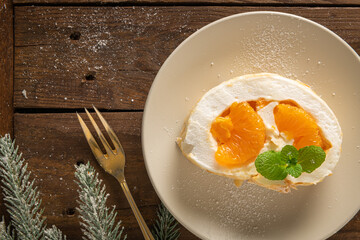 Meringue roll cake with cream, tangerine.