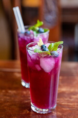 Purple cocktails with mint, blueberries and reusable straws