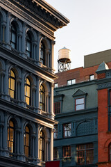 Cast iron facade of Soho loft building and rooftop water tower along Broadway. Soho Cast Iron Building Historic District, Lower Manhattan, New York City - 558355346