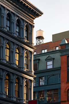 Cast iron facade of Soho loft building and rooftop water tower along Broadway. Soho Cast Iron Building Historic District, Lower Manhattan, New York City