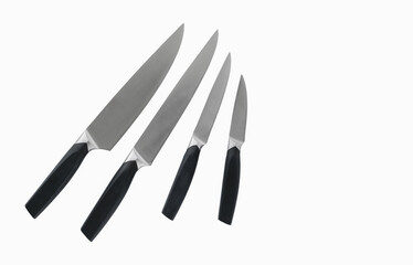 A set of sharp steel knives of different sizes, insulated on a white background. Kitchen knife. View from above. Copy space.
