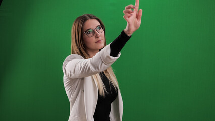 Young woman taps on a large imaginary touchscreen - studio photography