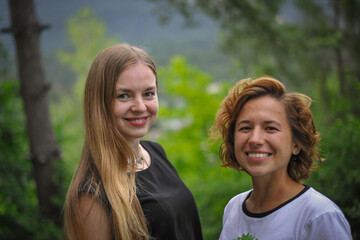 Obraz premium charming cute smiling girl friends with an open, honest faces and wide smiles against a forest in a soft light