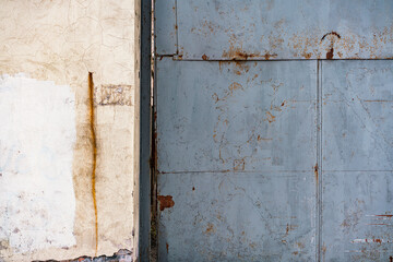 Huge grey rusty iron gate near the wall. Private territory. Factory. Control. Checkpoint. Metallic. Prohibition. Old warehouse. Entry. Entrance