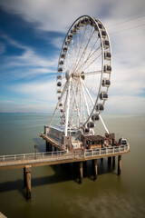 ferris wheel at de pier in den haag netherlands with blue cloudy sky