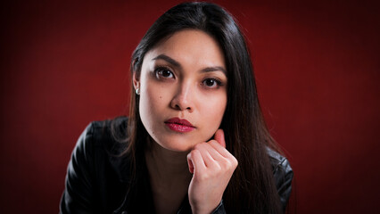 Young pretty woman in black leather jacket posing for the camera - studio photography