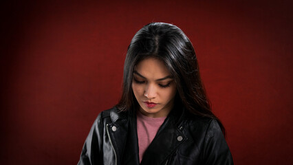 Fototapeta na wymiar Young pretty woman in black leather jacket posing for the camera - studio photography