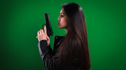 Young female agent with a gun in her hand - studio photography
