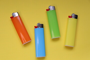 multi-colored lighters on a yellow background