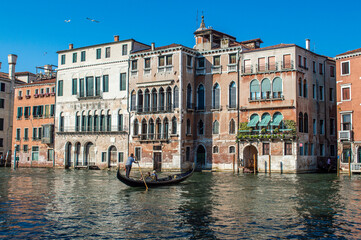 Fototapeta premium View of the Venetian Canal on a sunny day, buildings and boats. Venice, Italy 