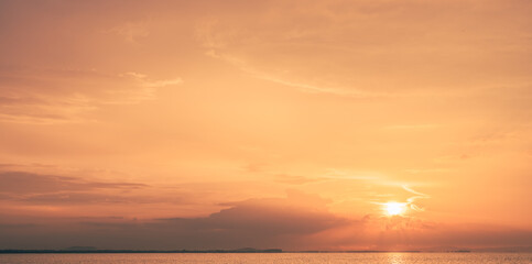 Evening sky orange colorful sunlight and dramatic sunset, Idyllic nature peaceful background with golden hour on dusk twilight over sea