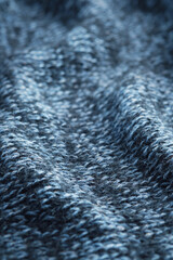 Texture knitted background. Folds of knitted woolen fabric close-up.