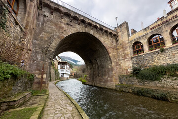 View of a medieval bridge over the river in the village of Potes in Cantabria, Spain. High quality photo