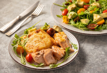 Salmon baked with cheese, served with vegetables.