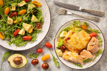 Salmon baked with cheese, served with vegetables.