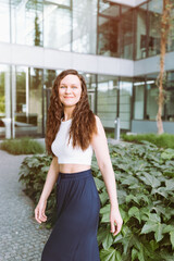 Young brunette woman in top and maxi skirt. Street city portrait