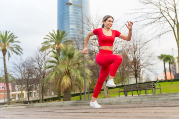 Fit woman in red clothes running fast in the city, fitness, sport