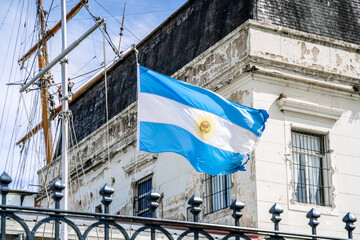 Argentinean flag on the background of an old historical building. Blue and white National symbol of...