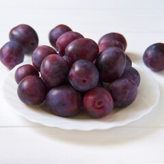 Fresh plum on a plate. White background
