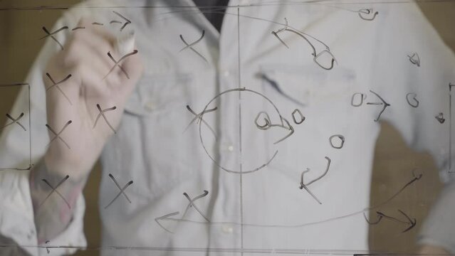 Hand drawing a soccer strategy plan on a glass screen